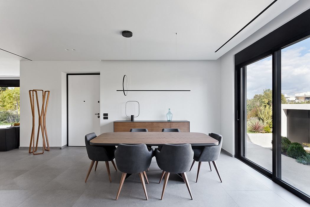 Modern dining room with sleek furniture, large windows, and minimalist decor.