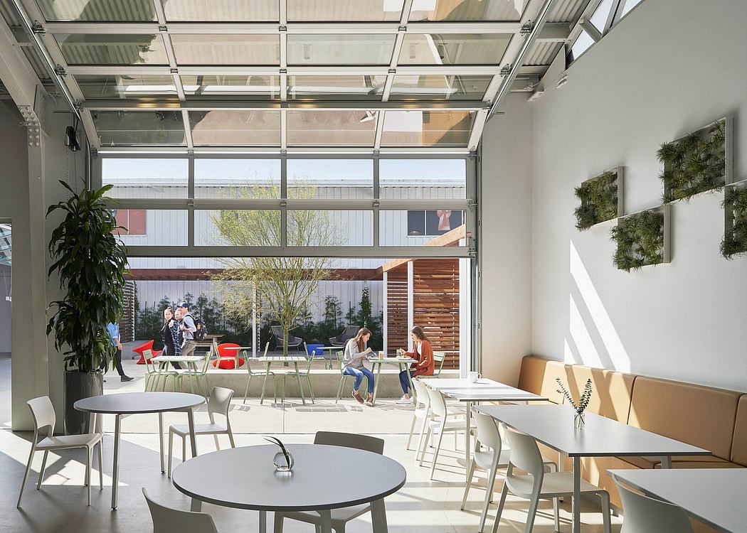 Bright, modern workspace with glass walls, greenery, and minimalist furnishings.