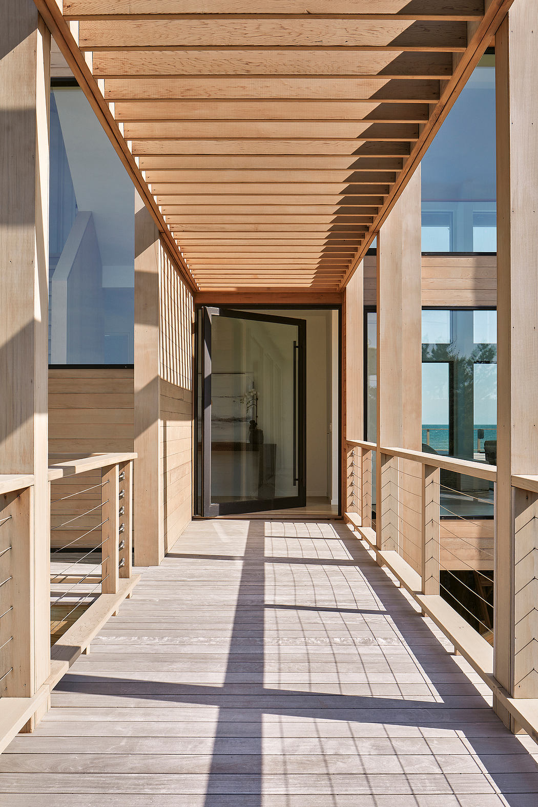 Wooden beams and glass windows create an airy, modern architectural design.