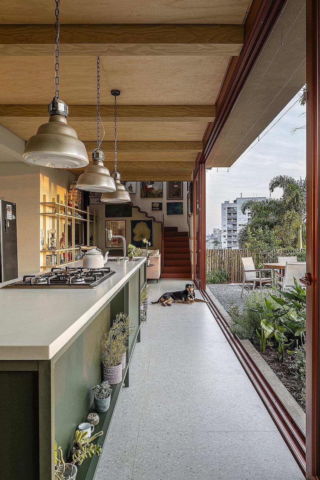 Rustic kitchen with hanging lights, wood ceiling beams, and a dog relaxing in the foreground.