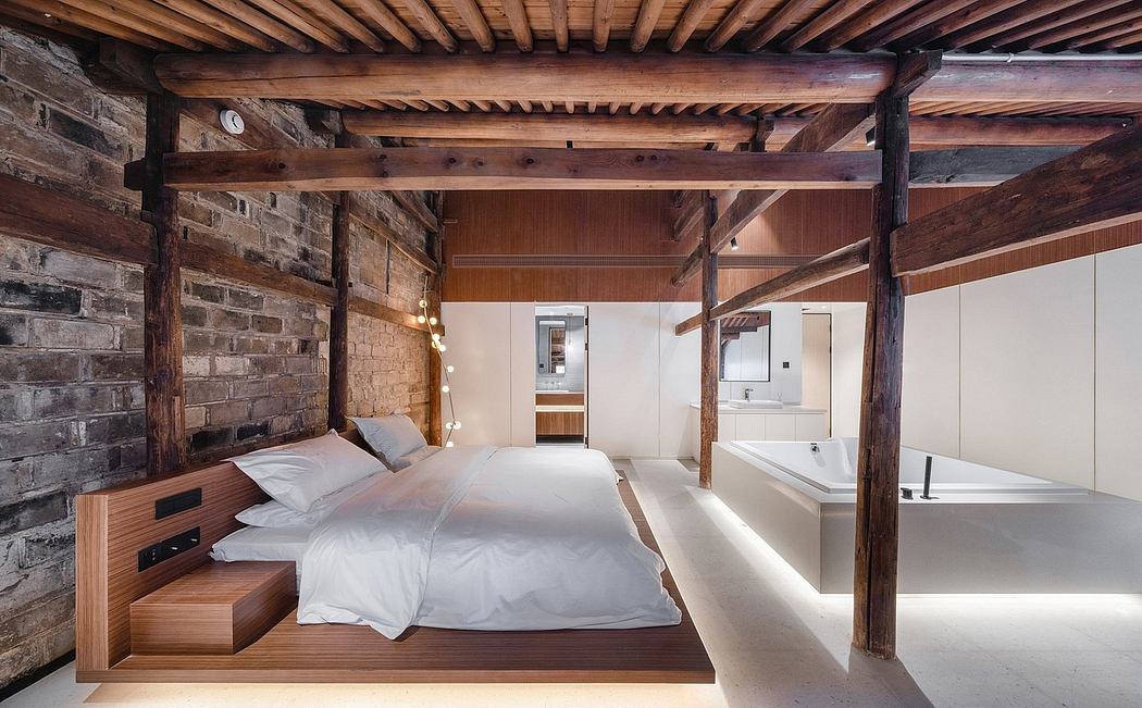 Rustic wooden beams, stone walls, and a modern, open-plan bedroom and bathroom layout.