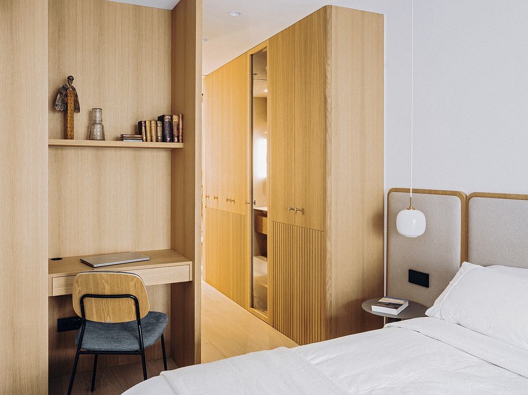 Modern, wood-paneled bedroom with built-in storage, desk, and minimalist decor.