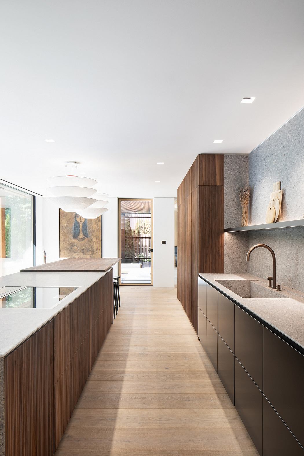 Modern kitchen with warm wood cabinetry, sleek countertops, and minimalist lighting.