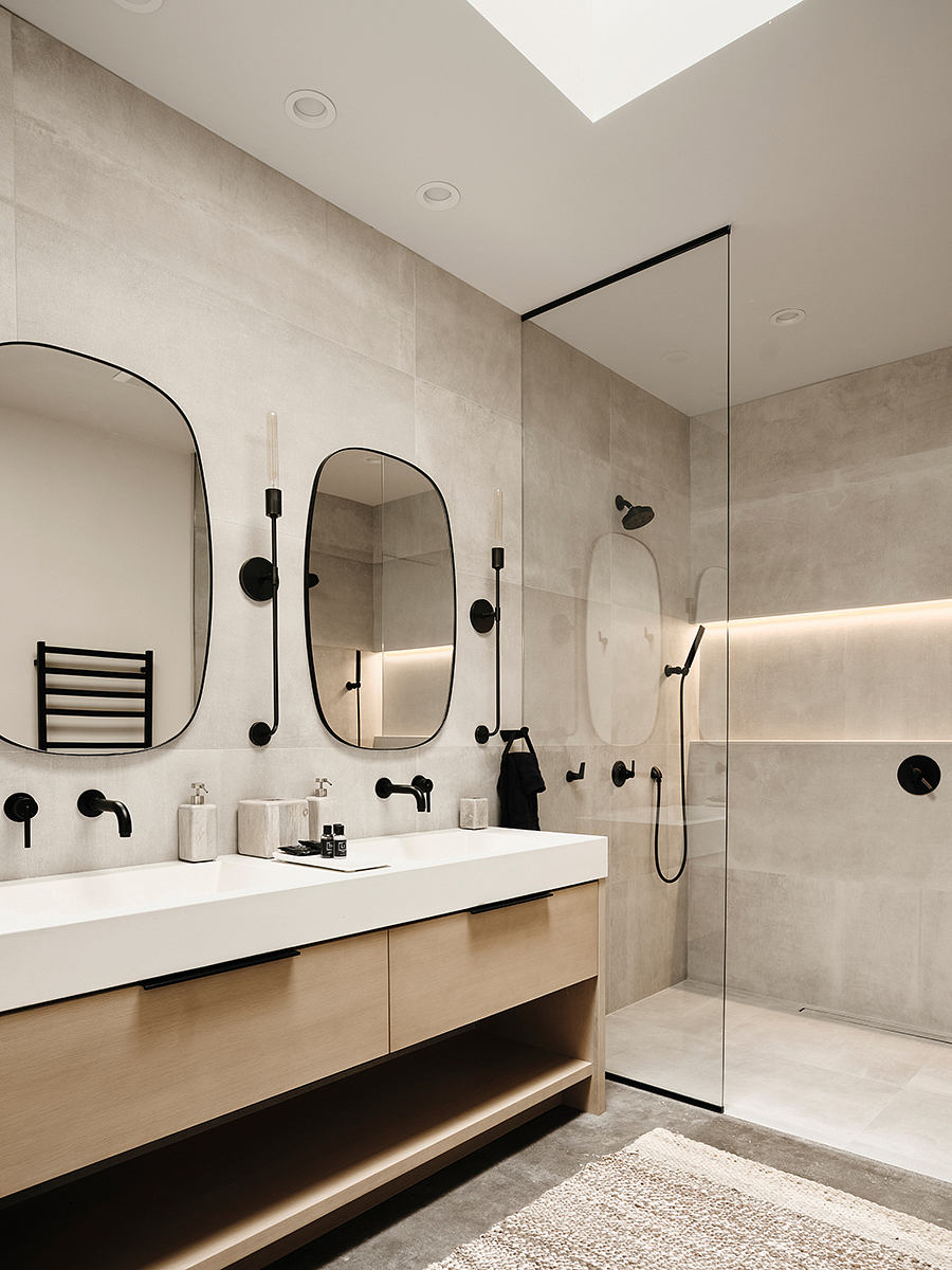 Spacious, modern bathroom with concrete walls, black accents, and minimalist vanity.