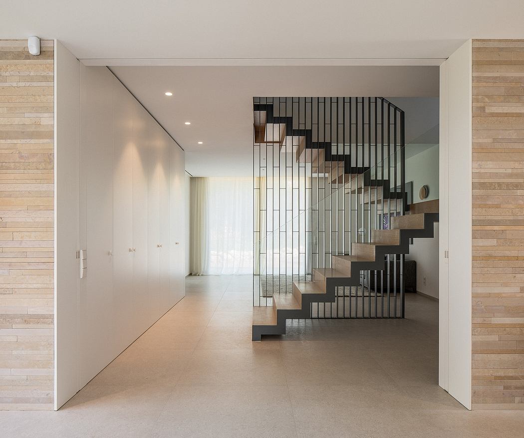 Minimalist interior with a striking staircase feature and contrasting wood paneling.