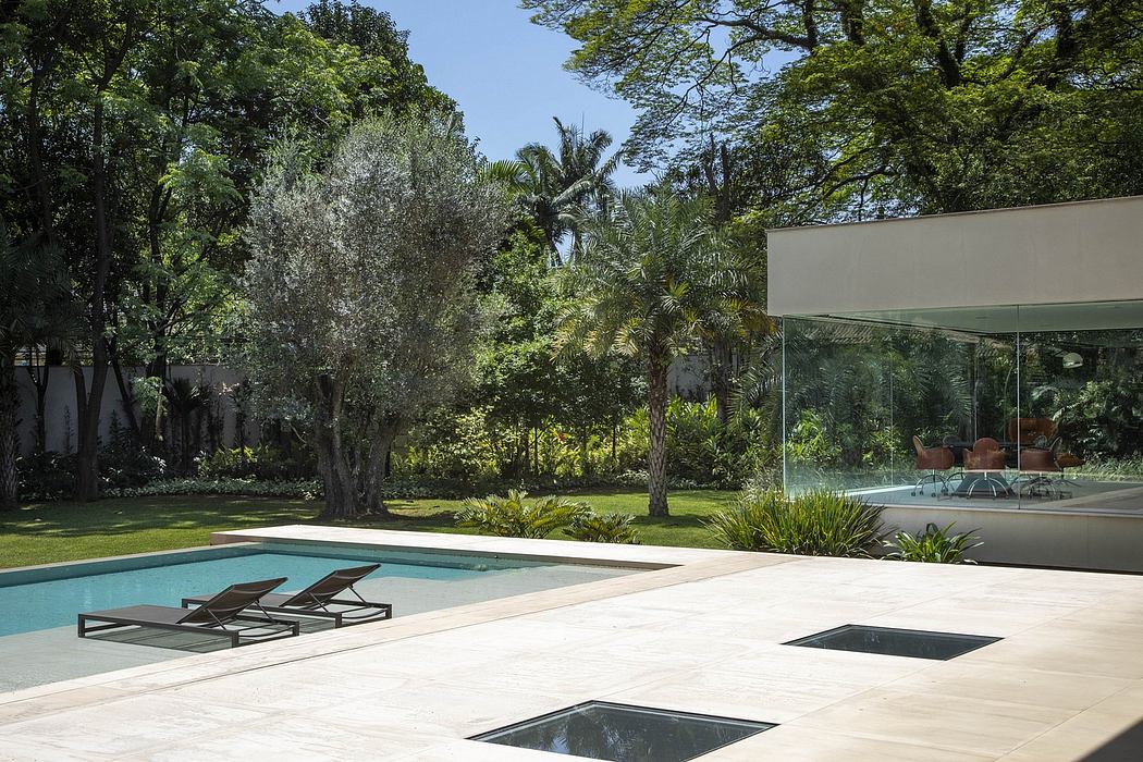 A modern outdoor oasis with a serene pool, lush foliage, and sleek architectural elements.