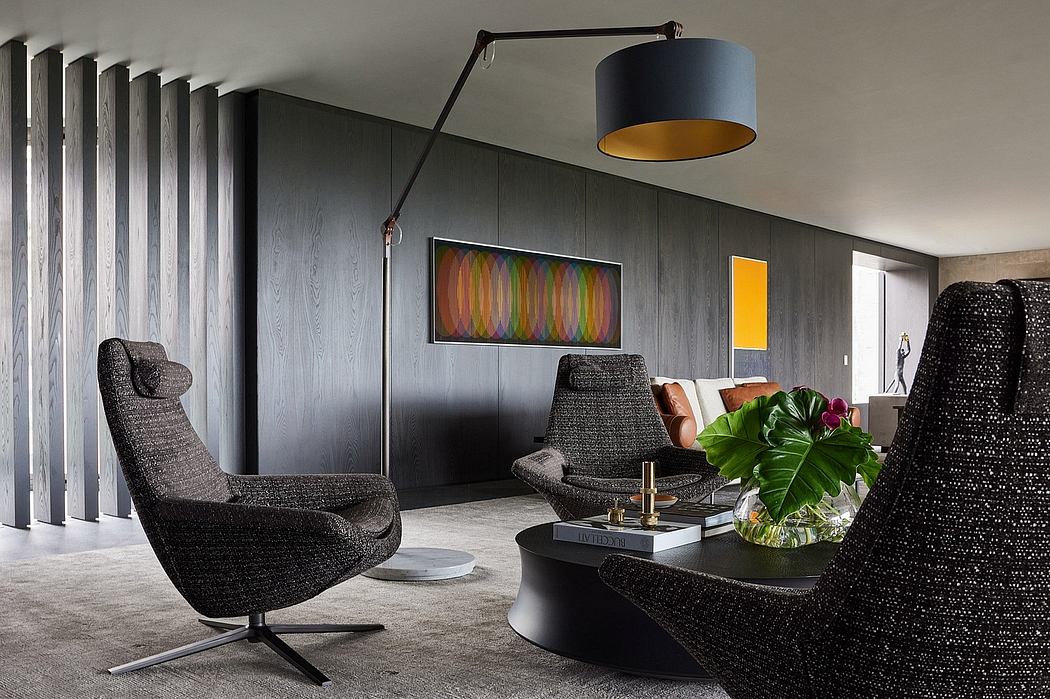 Sleek modern living room with black swivel chairs, colorful artwork, and a statement lamp.