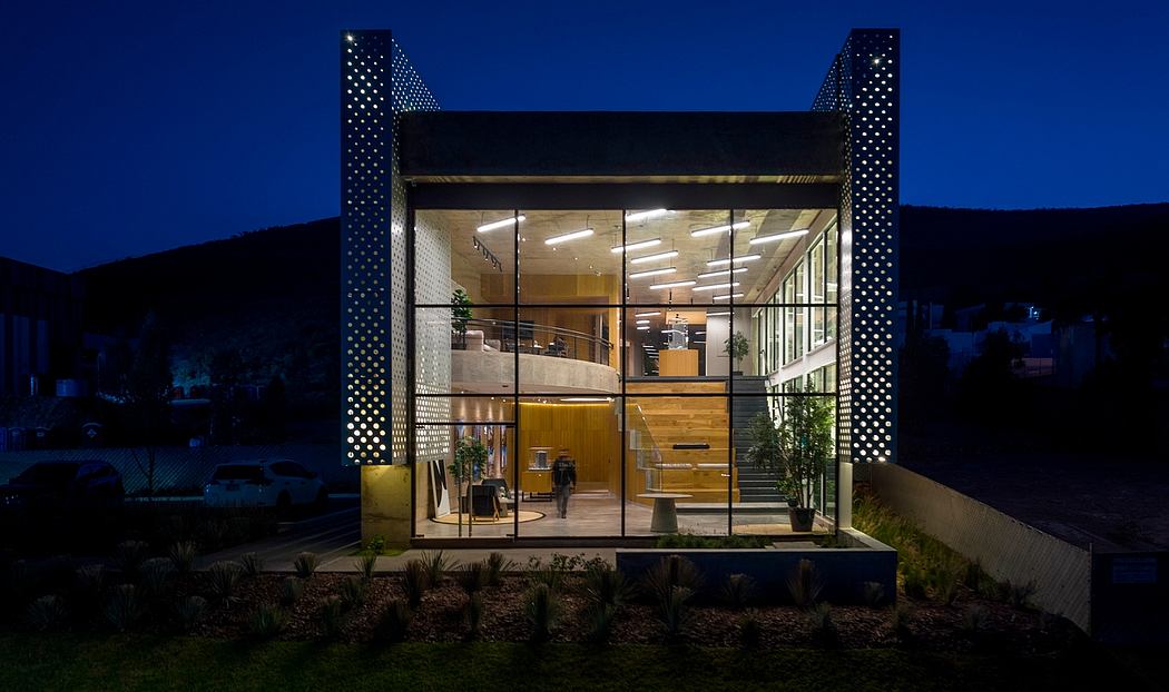 Striking modern glass building with polka dot accents and warm interior lighting.