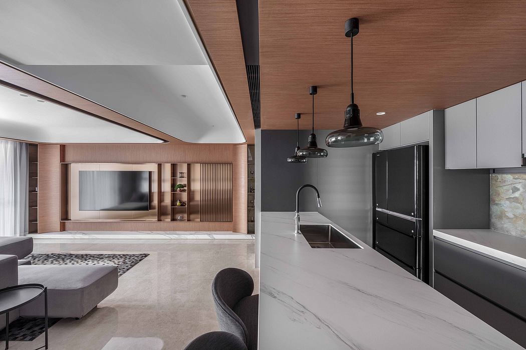 A modern, open-concept living space with sleek, marble-clad kitchen and suspended lighting.