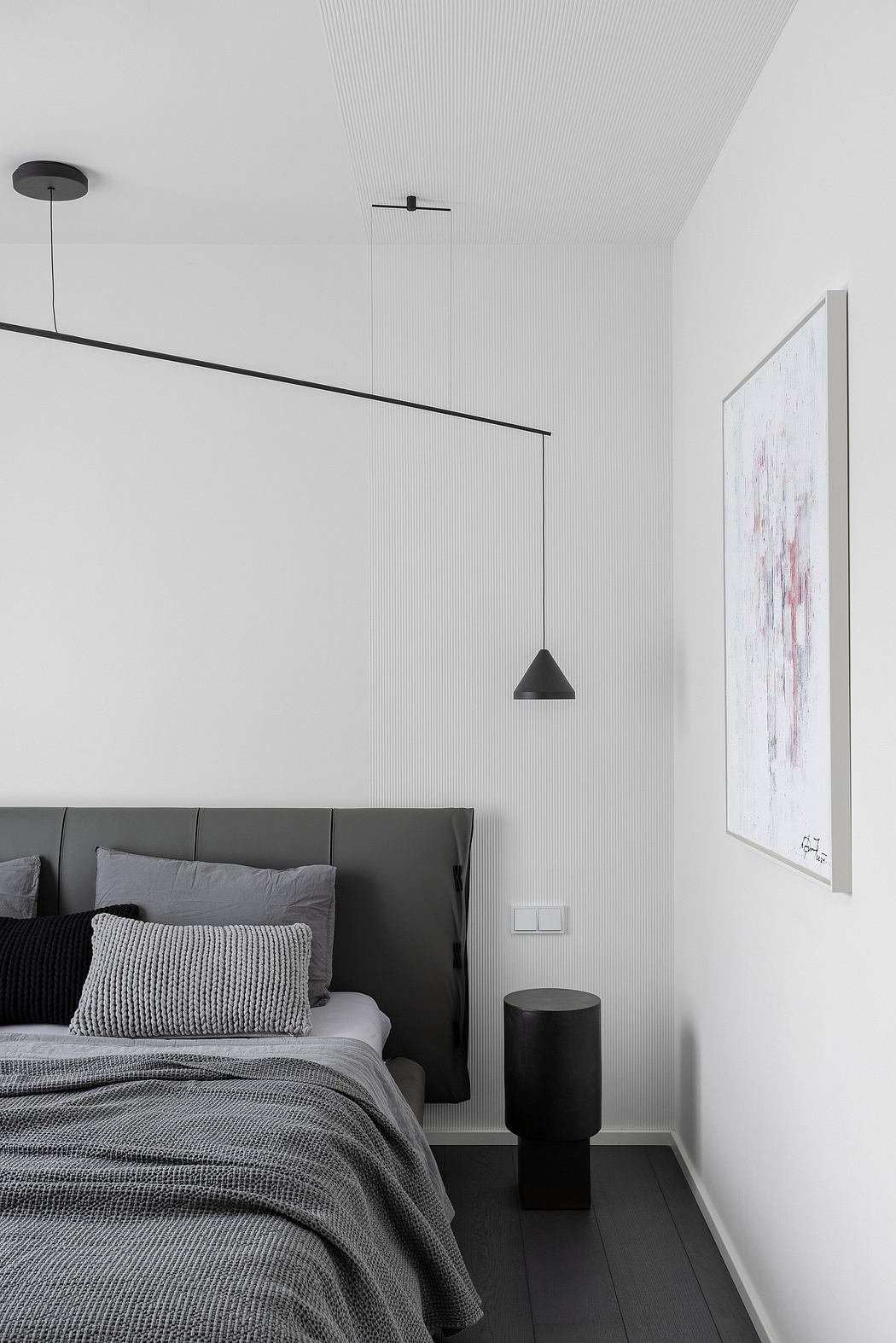 Modern, minimalist bedroom with clean lines, pendant lighting, and abstract artwork.