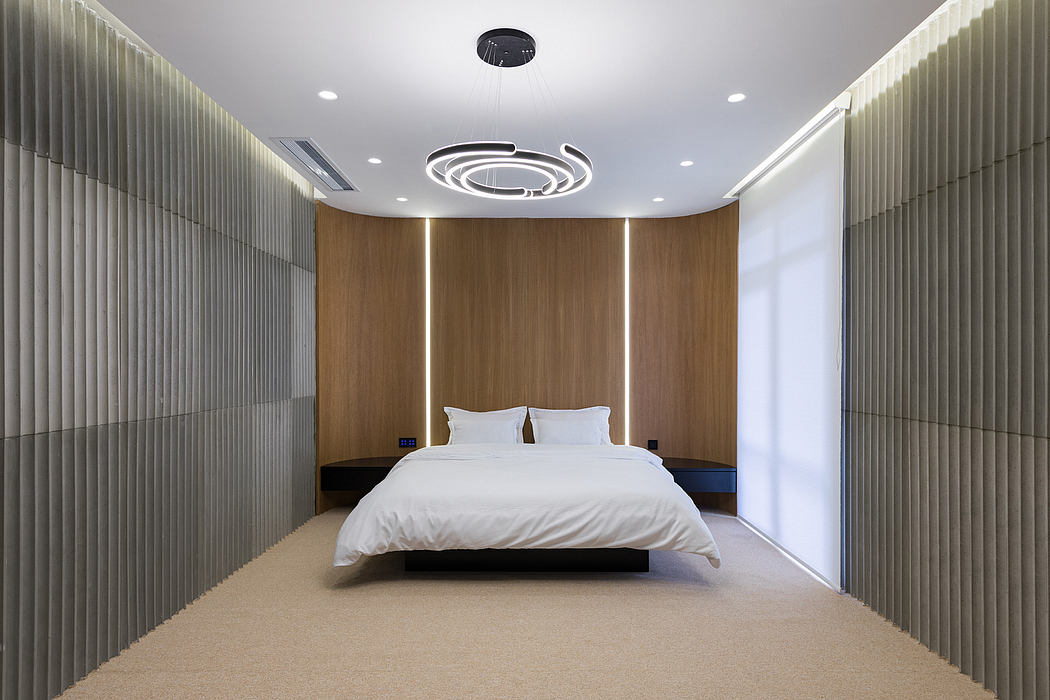A modern hotel room interior featuring sleek wood paneling, recessed lighting, and a large bed.