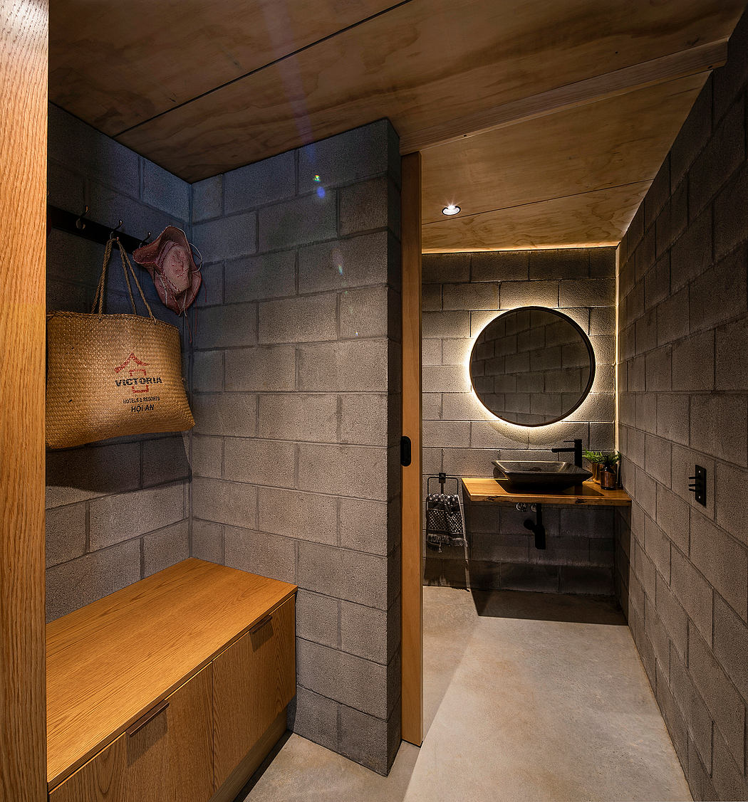Rustic bathroom features wooden ceiling, concrete walls, circular mirror, and vessel sink.