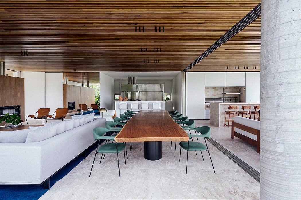 Expansive open-concept space with modern wooden beams, sleek white cabinets, and plush seating.