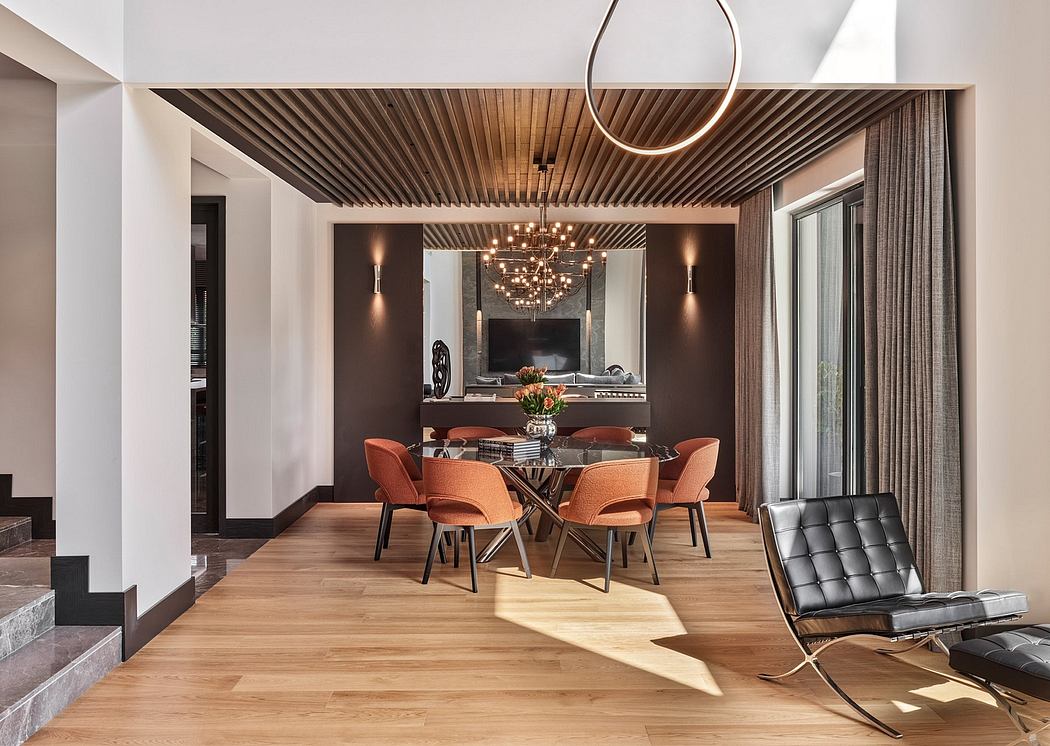 Modern dining room with wooden ceiling, lighting fixture, and orange accent chairs.
