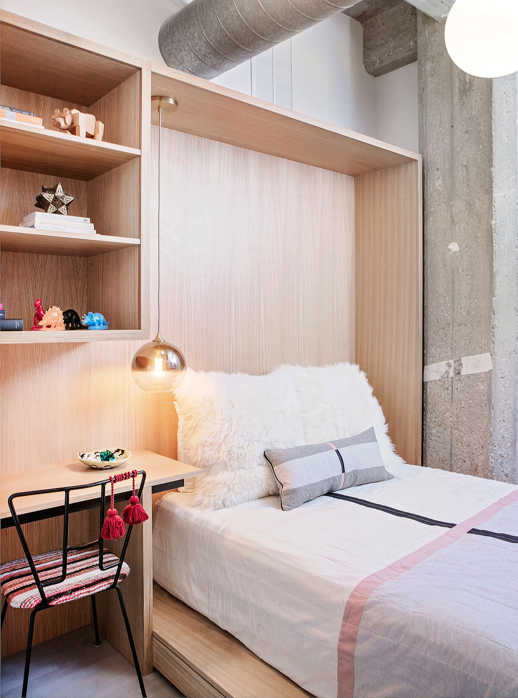 Cozy bedroom nook with wooden shelves, plush bedding, and metal accent chair.