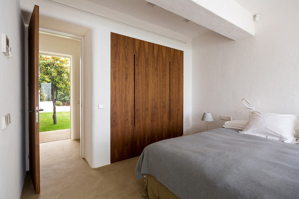 Spacious bedroom with modern wooden closet doors and access to outdoor garden.