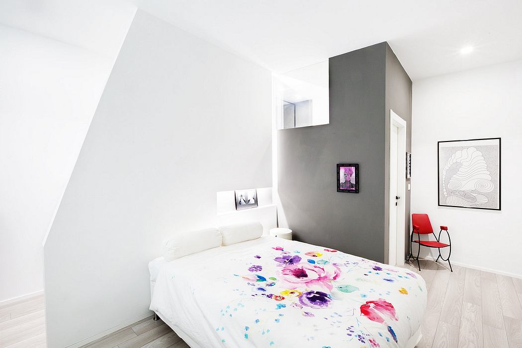 Minimalist bedroom with gray accent wall, floral bedding, and art decor highlighting clean lines.