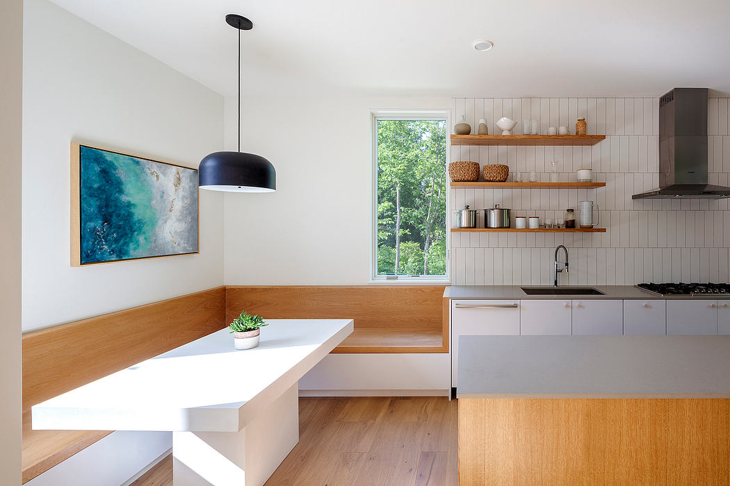 Modern kitchen with clean lines, open shelving, and a large window overlooking nature.