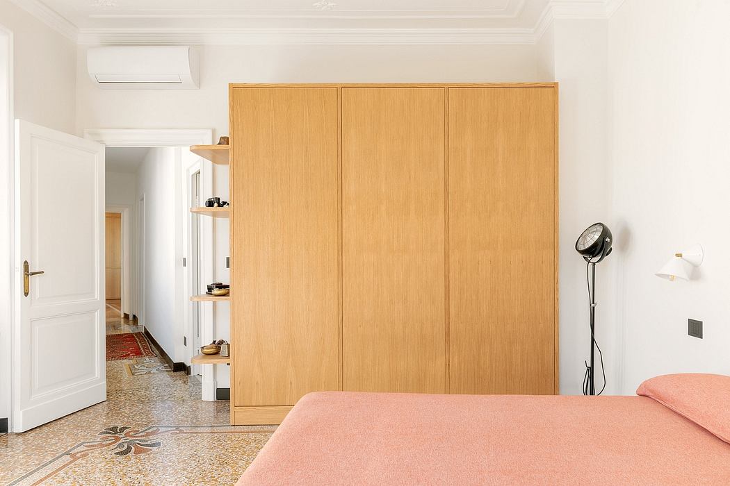 Spacious bedroom with wooden wardrobes, terrazzo flooring, and air conditioning unit.
