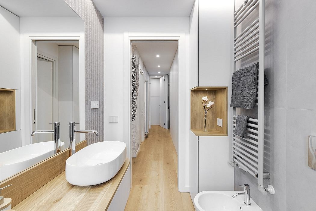 A modern, minimalist bathroom with a freestanding tub, wood accents, and a long hallway.