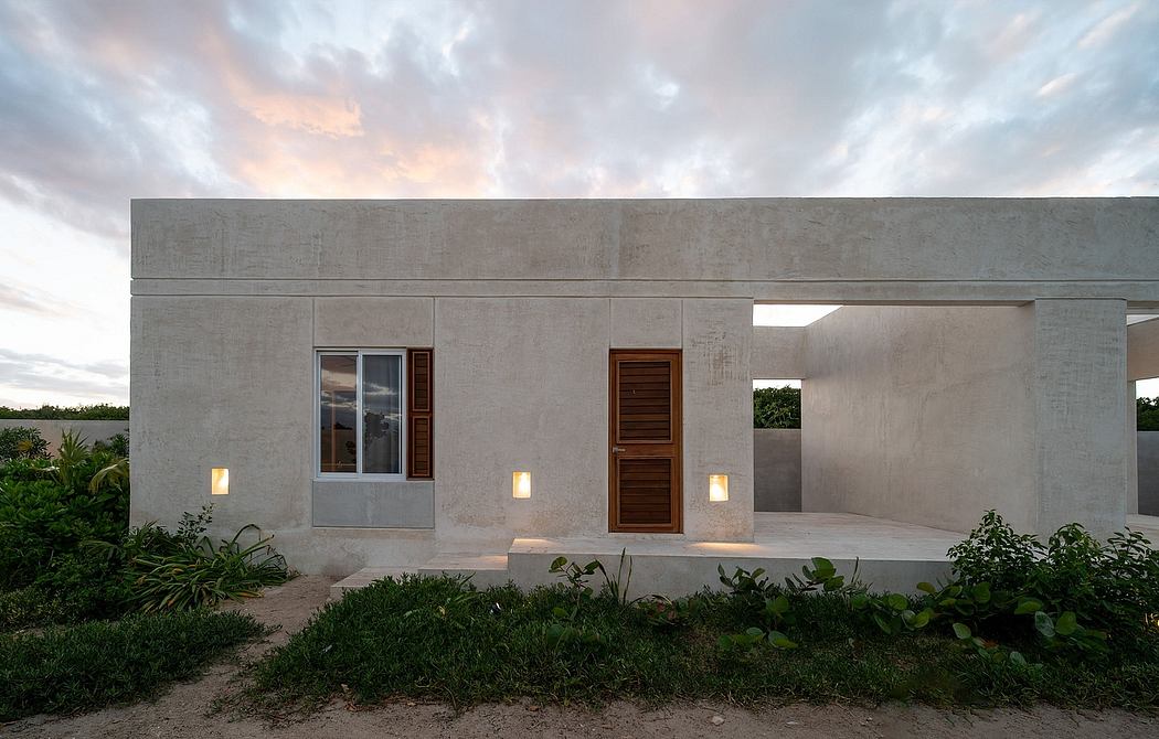 Modern concrete structure with wooden accents, surrounded by lush greenery.