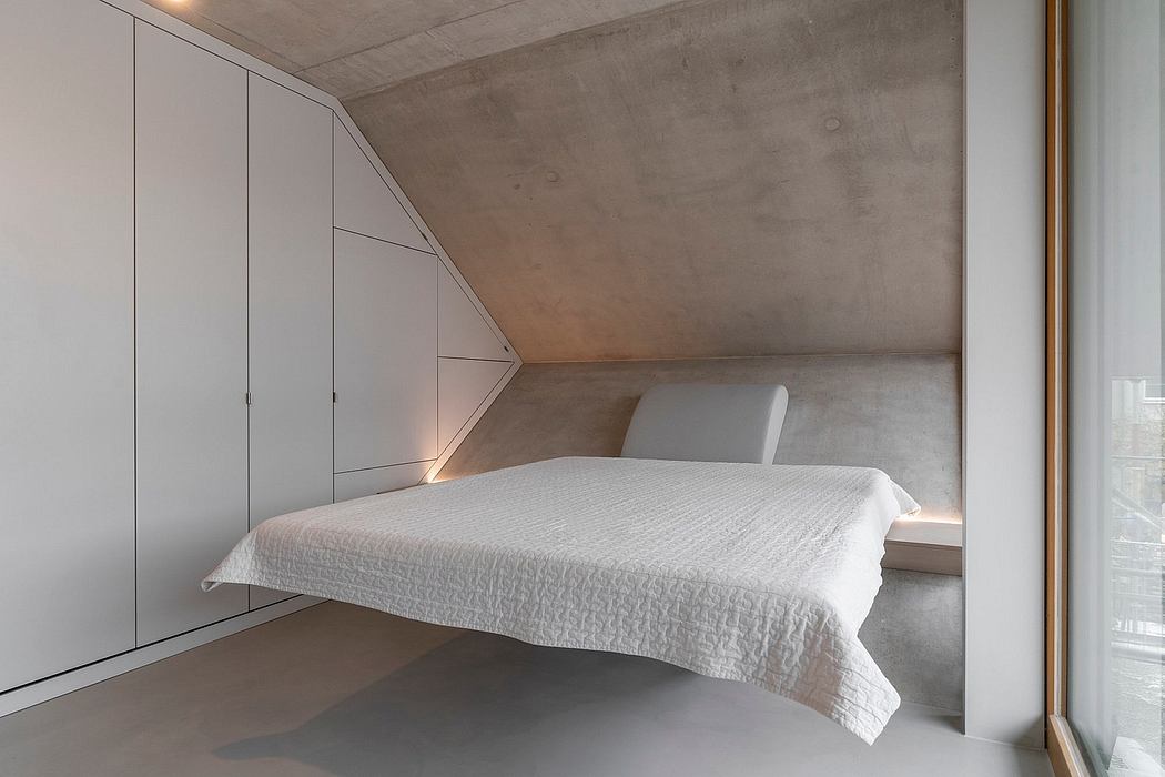 Minimalist bedroom design with concrete walls, built-in wardrobes, and a low-profile bed.