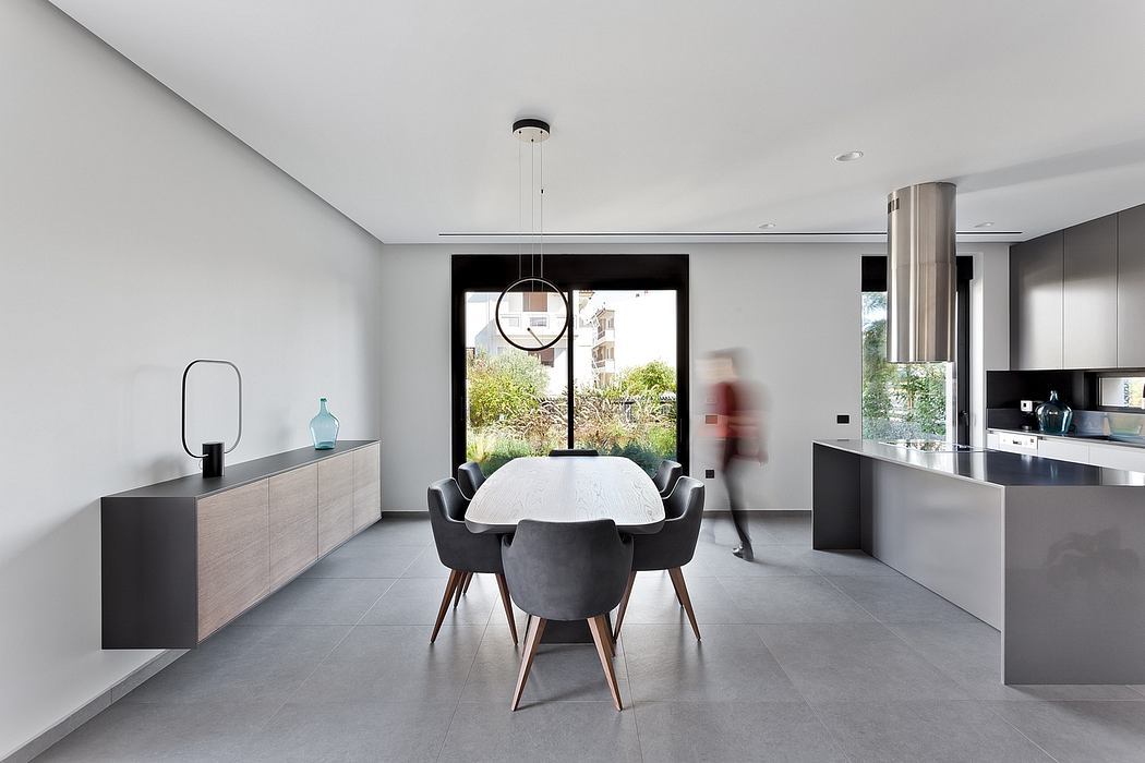 Modern, open-plan kitchen and dining area with sleek, minimalist design and large windows.