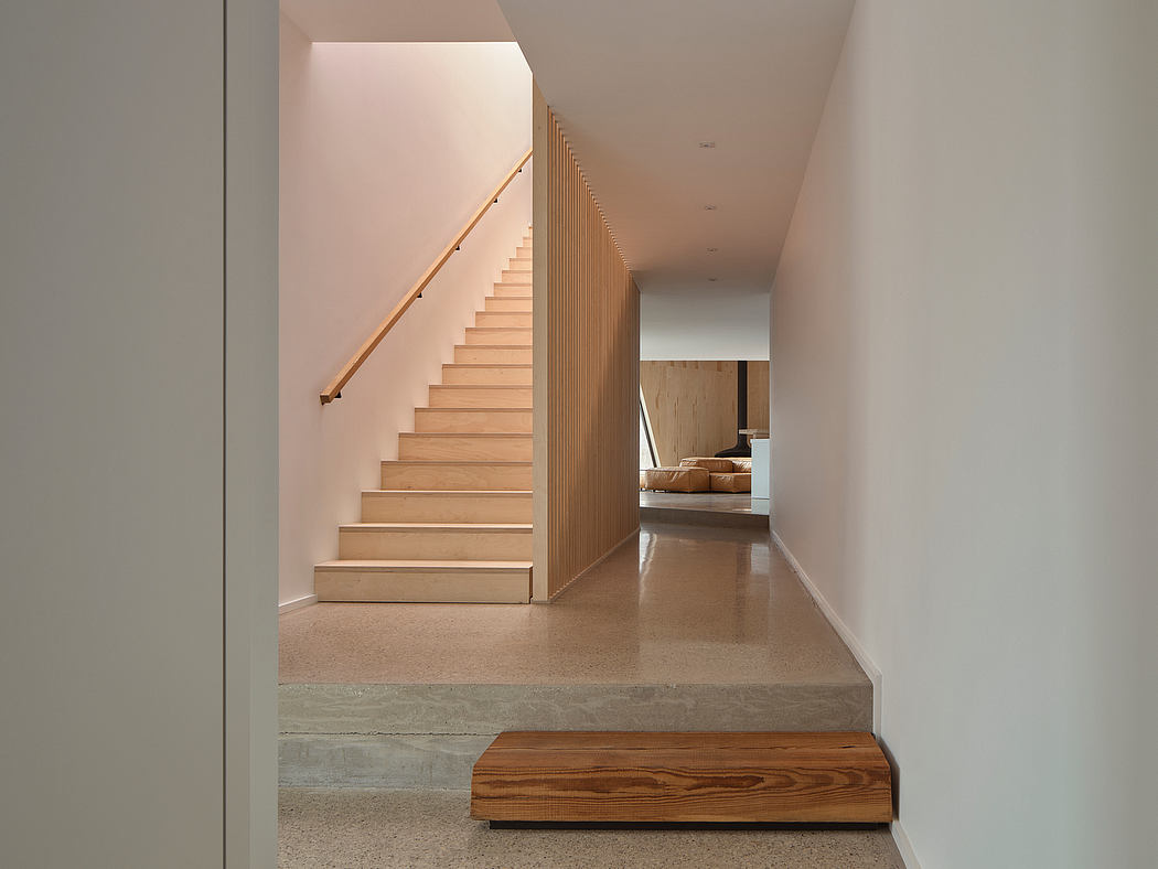 Minimalist staircase with wooden steps, concrete platform, and linear wood paneling.