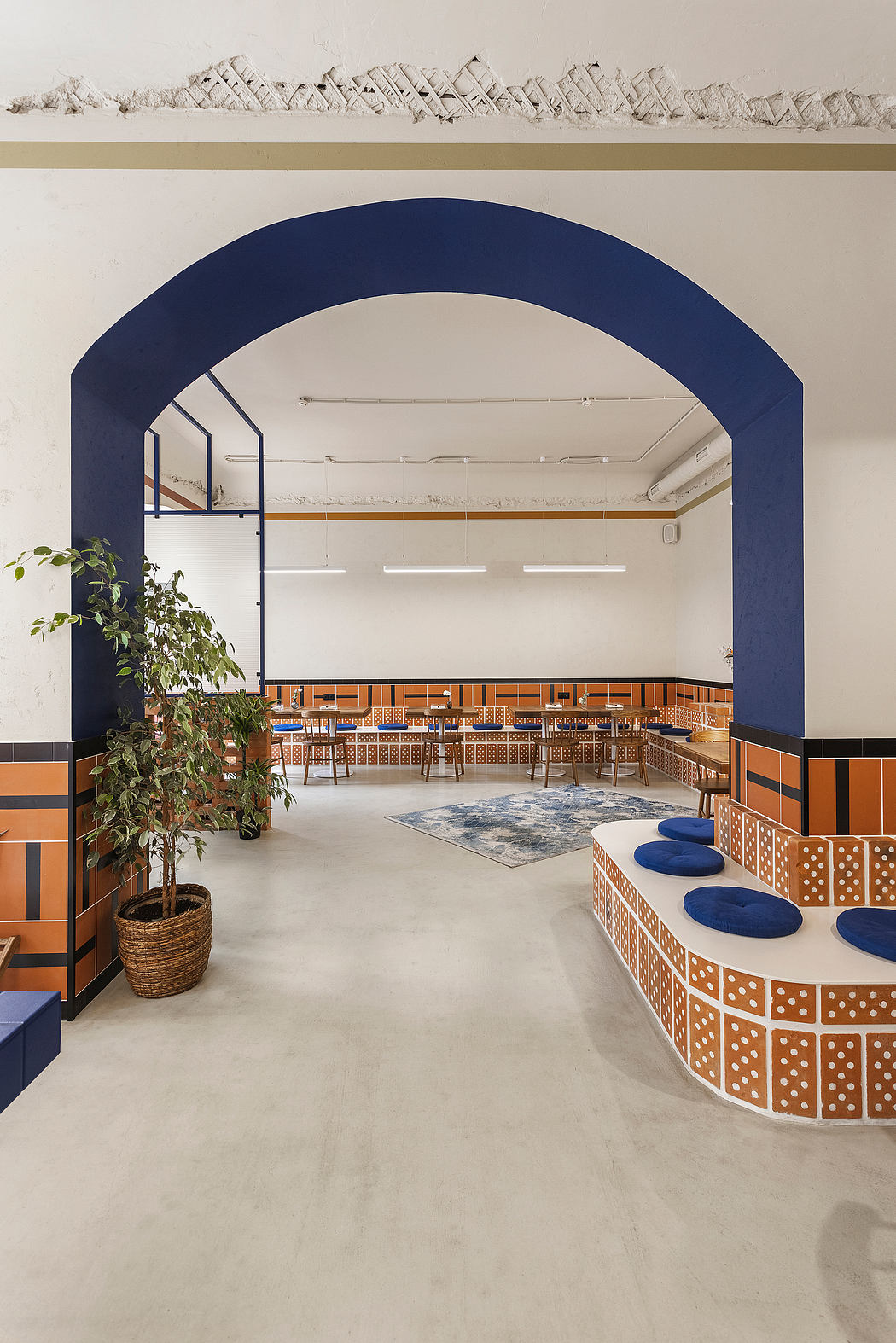 A modern interior with arched doorway, geometric tile patterns, and a central seating area.