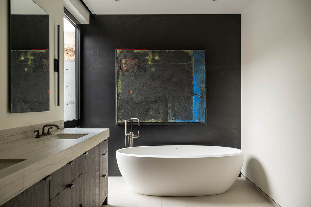A modern bathroom with a freestanding tub, sleek vanity, and abstract artwork on the dark walls.