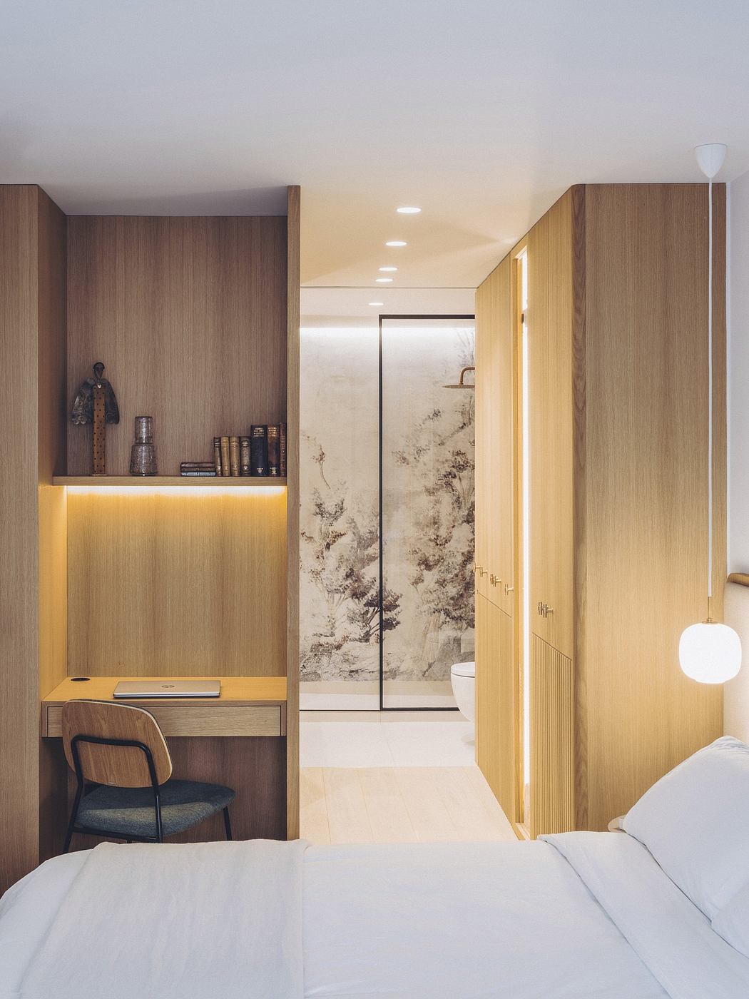 Cozy bedroom with warm wooden paneling, built-in shelving, and hidden bathroom entry.