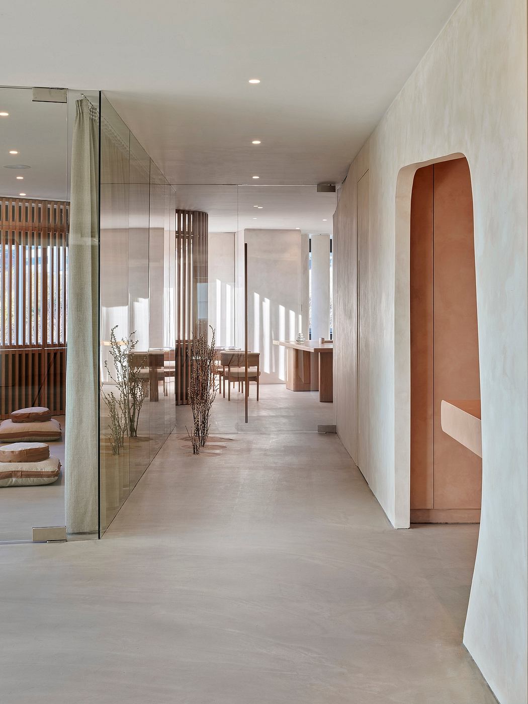 A modern, minimalist hallway with warm wood accents, glass walls, and recessed lighting.