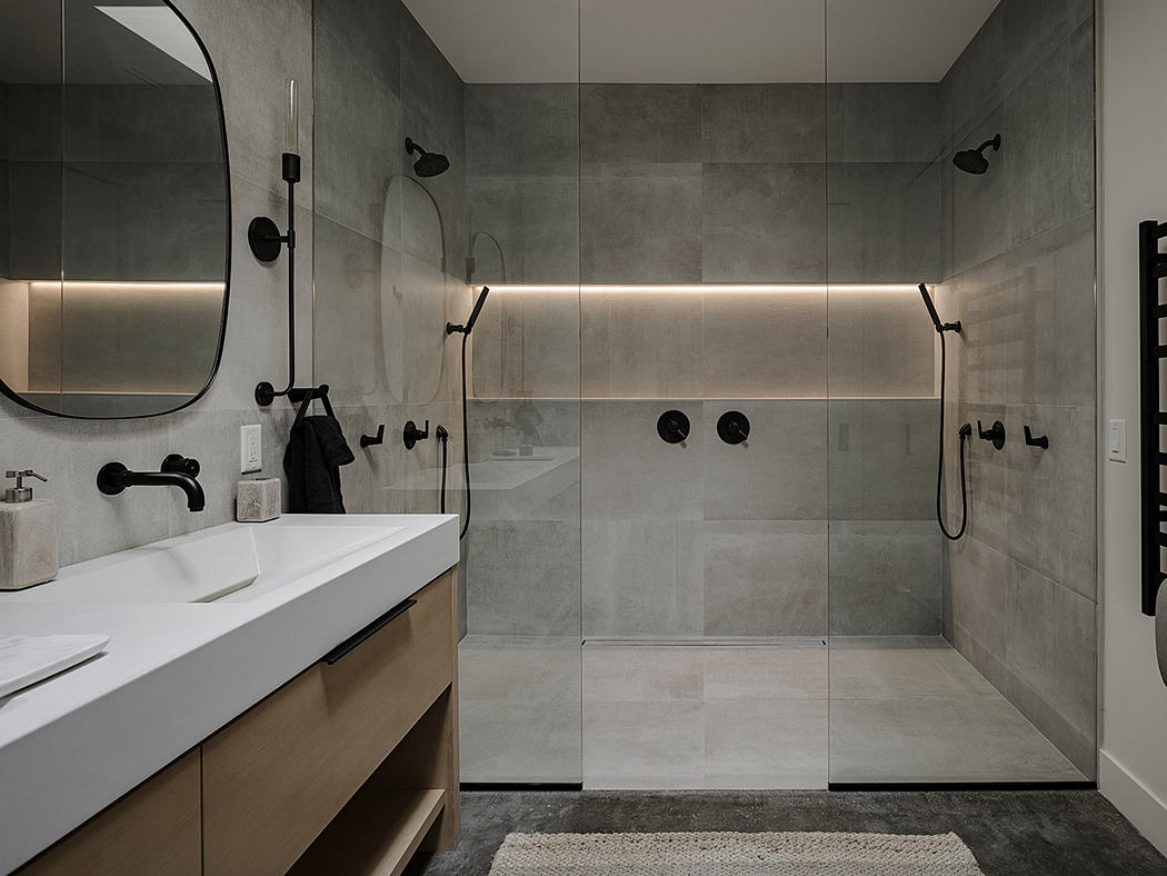 A modern, minimalist bathroom with sleek gray tiles, a floating vanity, and contemporary fixtures.