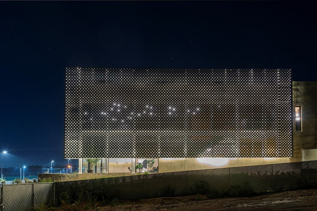 Striking facade of perforated metal panels featuring a captivating light display.