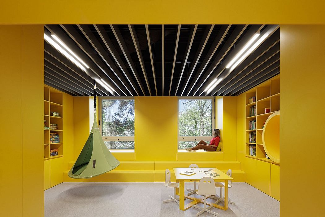 Vibrant yellow interior with sleek black ceiling beams and cozy reading nook.