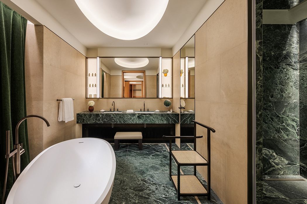 Luxurious bathroom with sleek marble vanity, circular mirrors, and an expansive tub.