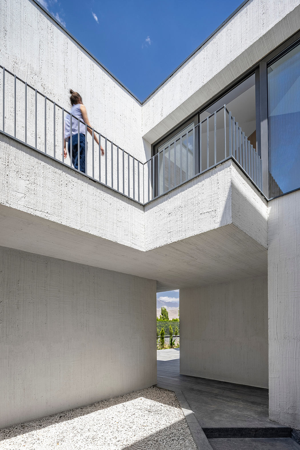 Striking concrete structure with geometric balconies and expansive windows.