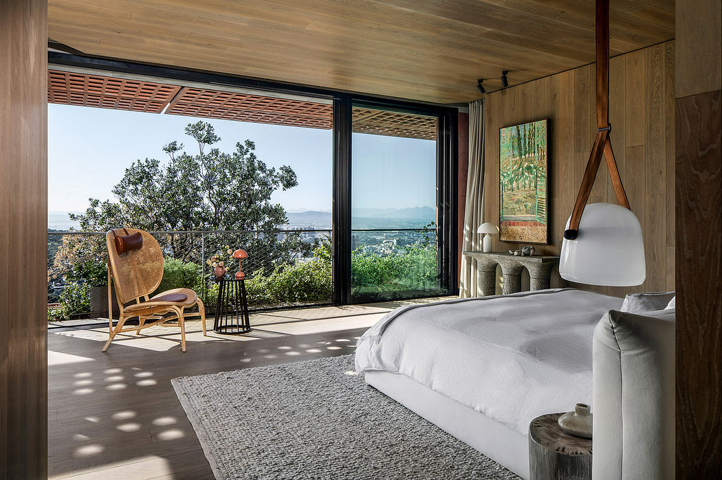 Expansive bedroom with floor-to-ceiling windows, wooden paneling, and nature-inspired decor.