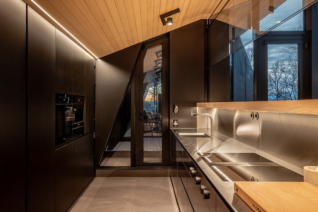 Sleek, modern kitchen with wood panels, stainless steel appliances, and glass walls offering scenic views.