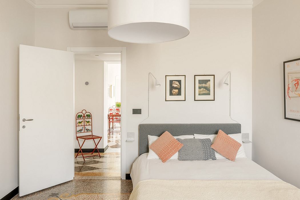 A modern, minimalist bedroom with abstract artwork and a floor-to-ceiling shelving unit.