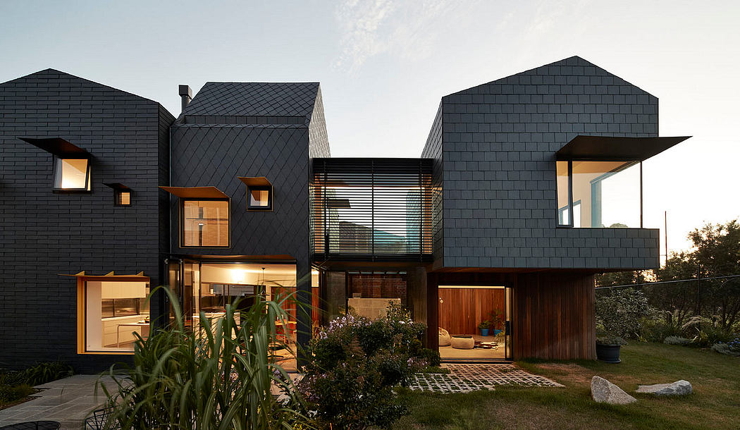 A striking modern home with a black exterior, large windows, and an open floor plan.