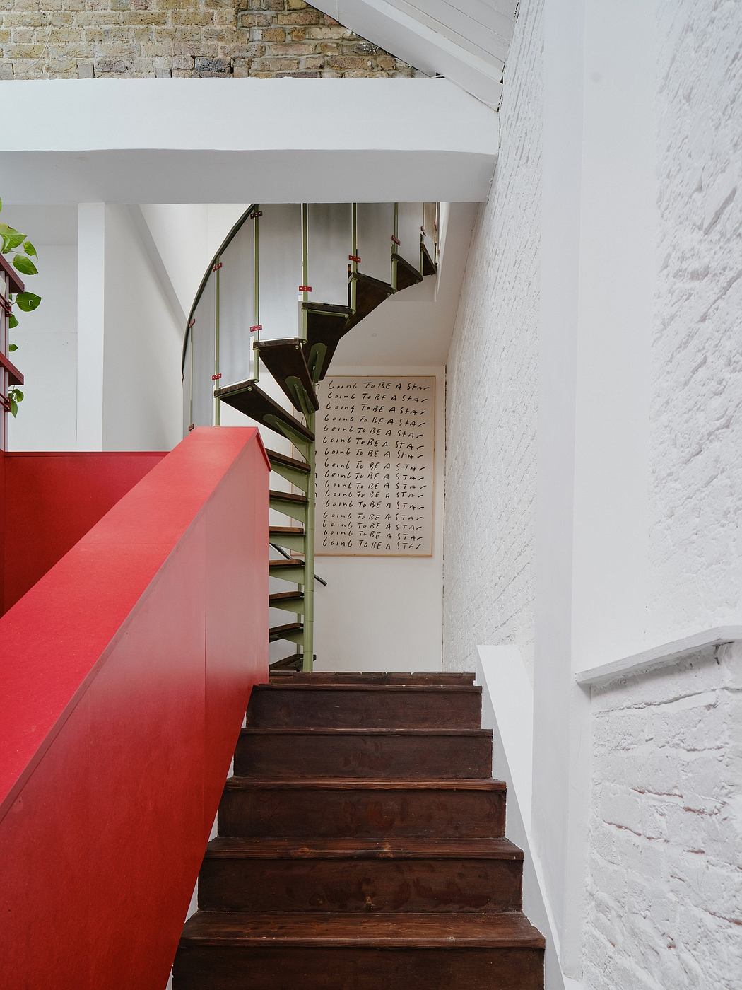 Striking interior design with bold red staircase and handwritten wall art.