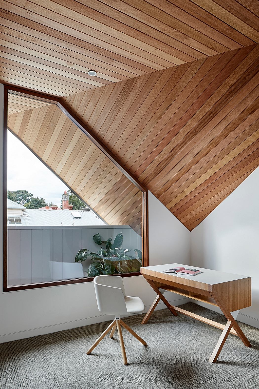 Striking wooden slat ceiling and modern desk in minimalist home office interior.