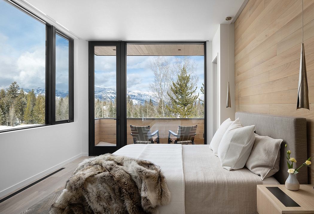 Spacious, modern bedroom with large windows offering panoramic mountain views, cozy textures.