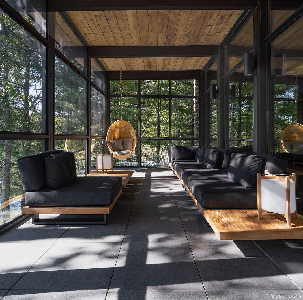 Striking architectural design featuring wooden beams, glass walls, and contemporary furnishings.