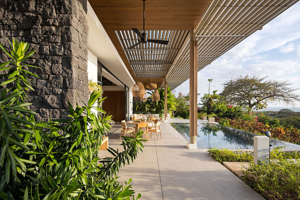 Luxurious outdoor patio with wood-slatted ceiling, stone walls, and infinity pool.