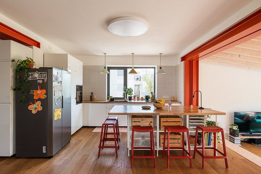 Modern kitchen with bright red accent chairs, wood countertop, and tiled backsplash.