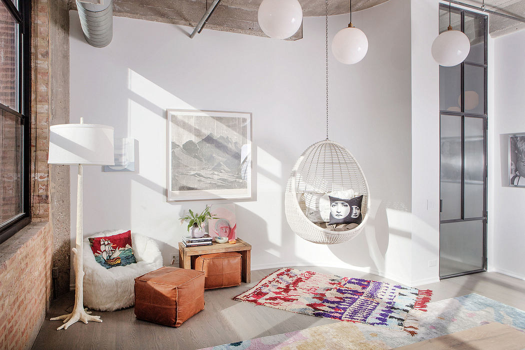 A bright, modern industrial-style space featuring hanging globe lamps and cozy seating.