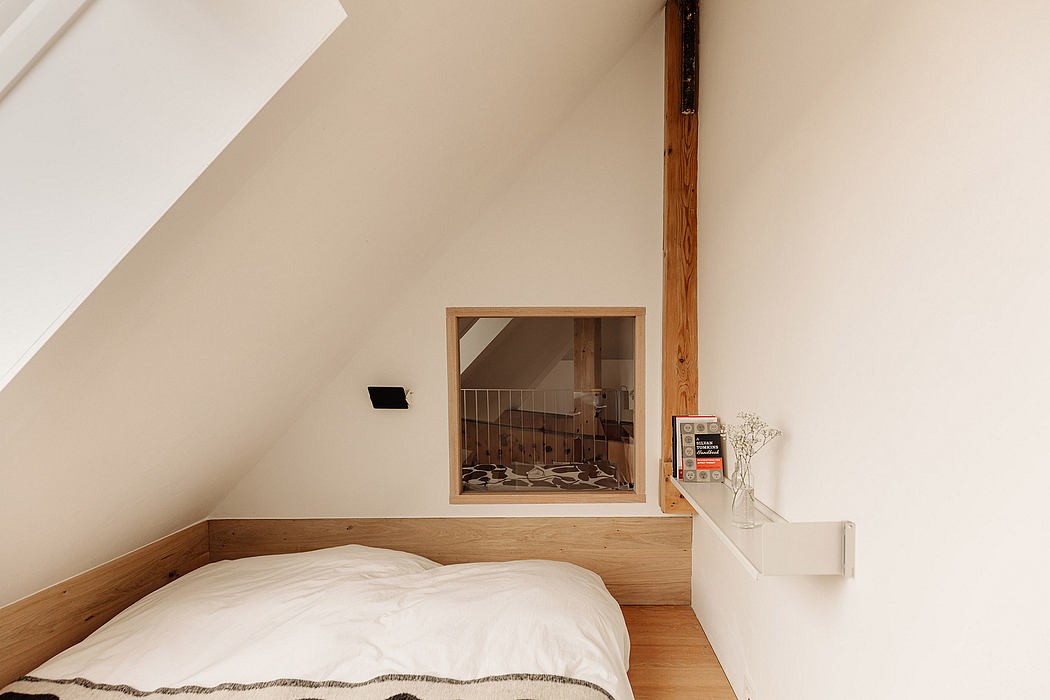 Cozy attic bedroom with wooden walls, slanted ceiling, and built-in shelving.