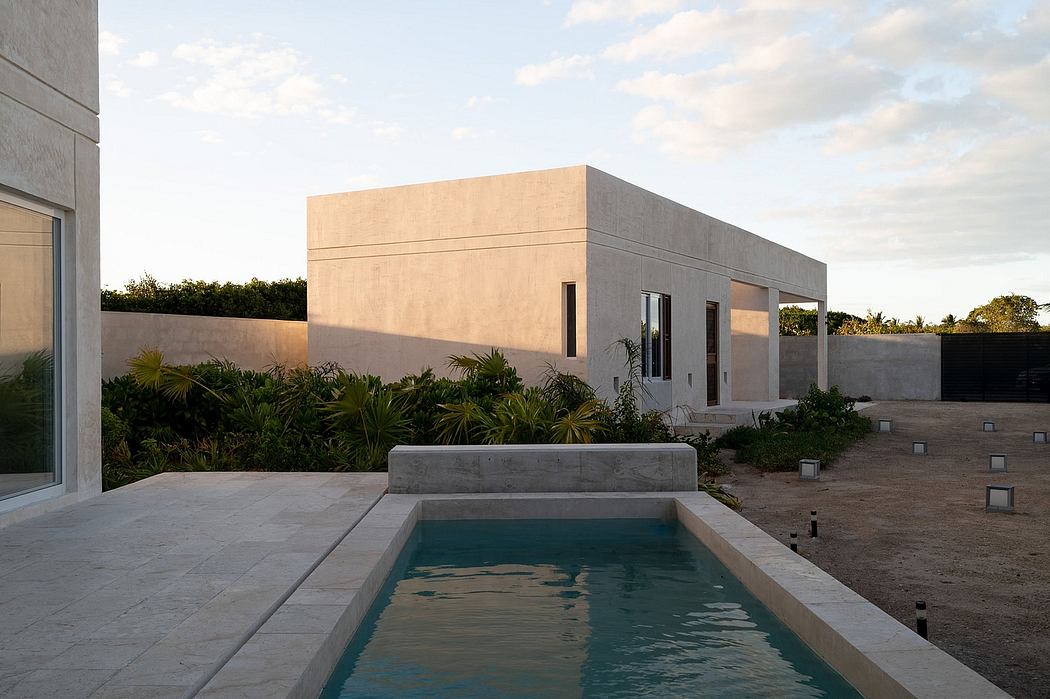 Modern architectural design with sleek concrete exterior, large windows, and minimalist swimming pool.